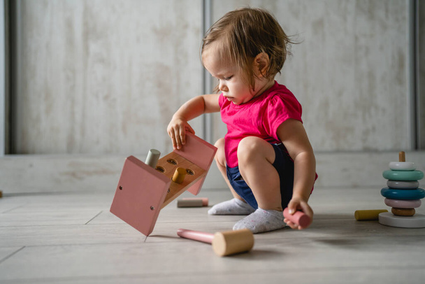ein Kind kleine kaukasische Mädchen kleines Kleinkind spielen mit Lernspielzeug zu Hause Kindheit und Aufwachsen frühe Entwicklung Konzept kopieren Raum Seitenansicht - Foto, Bild