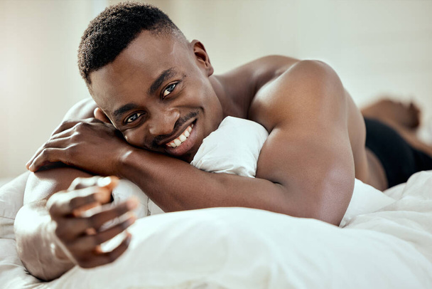 Portrét pohledného mladého muže ležícího na posteli. - Fotografie, Obrázek