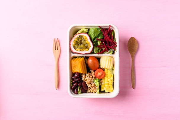 Салат зі свіжих овочів у біорозкладаній мисці на рожевому фоні, Здорова веганська їжа
 - Фото, зображення
