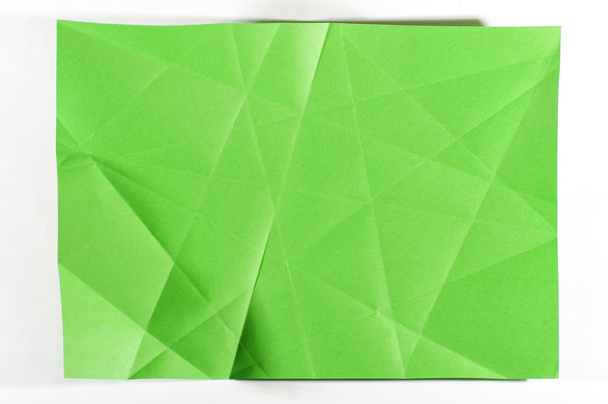Green folded sheet of paper isolated on the bright background - Фото, зображення
