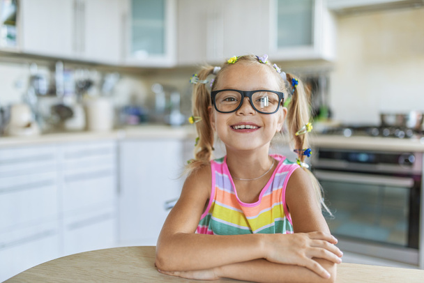 pequeña chica alegre en gafas sentado
 - Foto, imagen