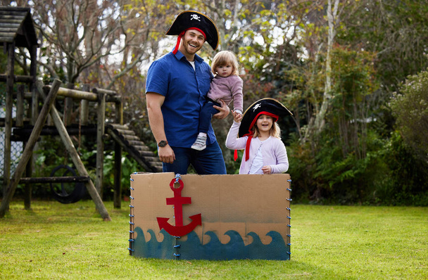 a father and daughters dressed up like pirates outside in the yard. - Photo, Image