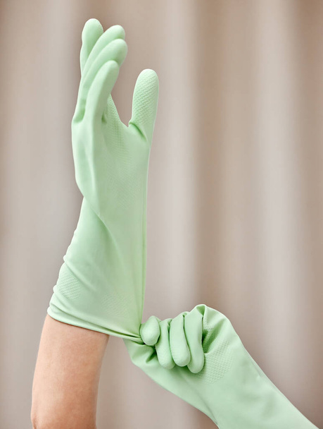 an unrecognizable person putting on gloves at home. - Fotó, kép
