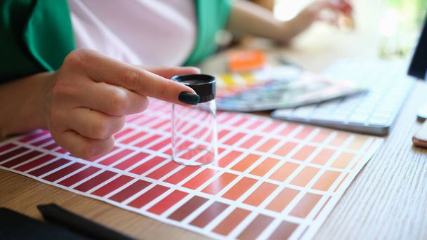 Close-up of graphic designer choosing colors samples and looking through magnifying glass. Female searching proper colour for promotion. Design concept - Photo, image