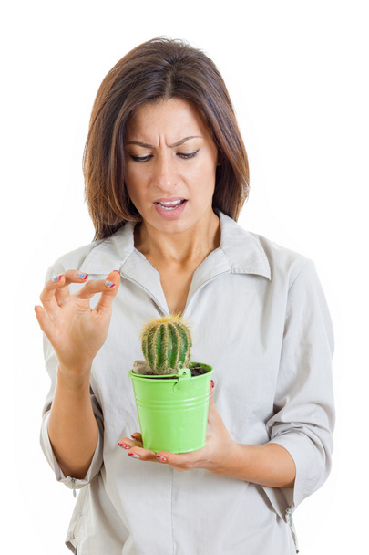 Frau hielt Kaktuspflanze in der Hand und stach mit schmerzhaftem Finger auf sie ein - Foto, Bild