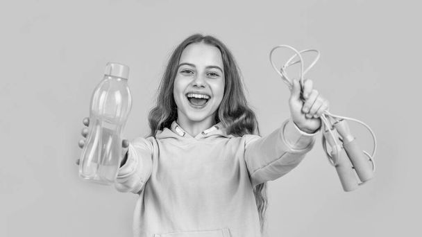 happy smiling teen girl hold sport or fitness equipment of jumping rope and water bottle, refreshment. - Foto, Imagen