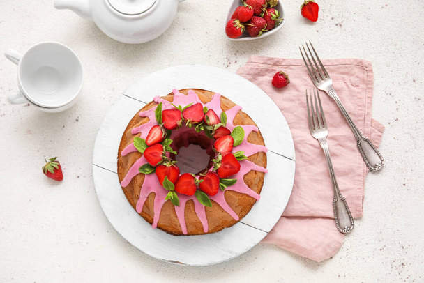 Plate with tasty strawberry cake on light background - 写真・画像