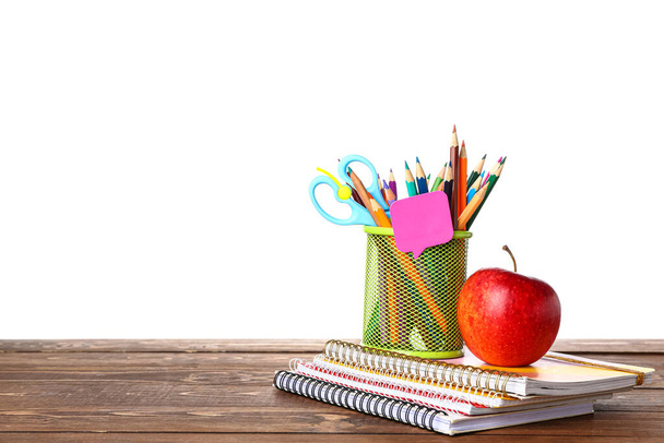 School stationery with apple on wooden table against white background - Foto, Imagem