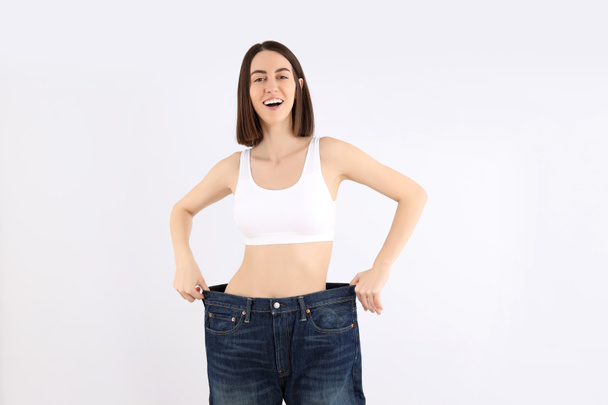 Concept of weight loss with slim young woman on light background - 写真・画像