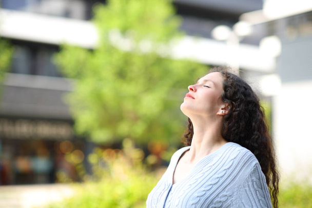 Profile of a woman relaxing breathing fresh air in the street - Foto, Bild