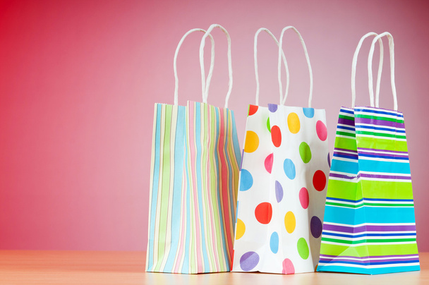 Colourful paper shopping bags against gradient background - Fotó, kép