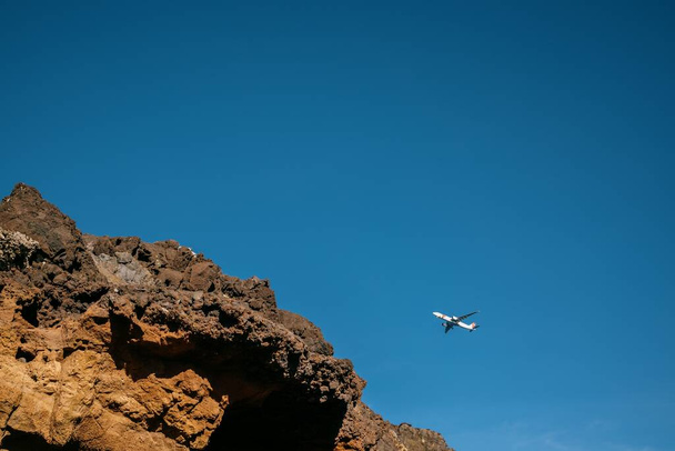 A scenic view of an airplane flying in the blue sky in Madeira, Portugal - Photo, Image