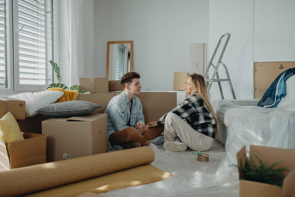 A cheerful young couple in their new apartment. Conception of moving. - Fotó, kép