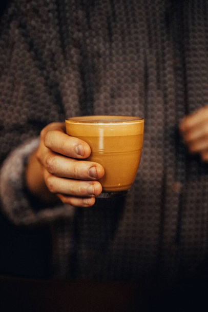 A vertical closeup of a man serving a cup of coffee - Foto, immagini