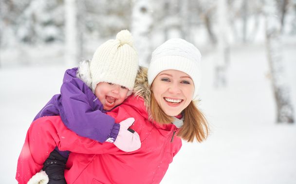 onnellinen perhe äiti ja vauva tyttö tytär leikkii ja nauraa talvella lunta
 - Valokuva, kuva