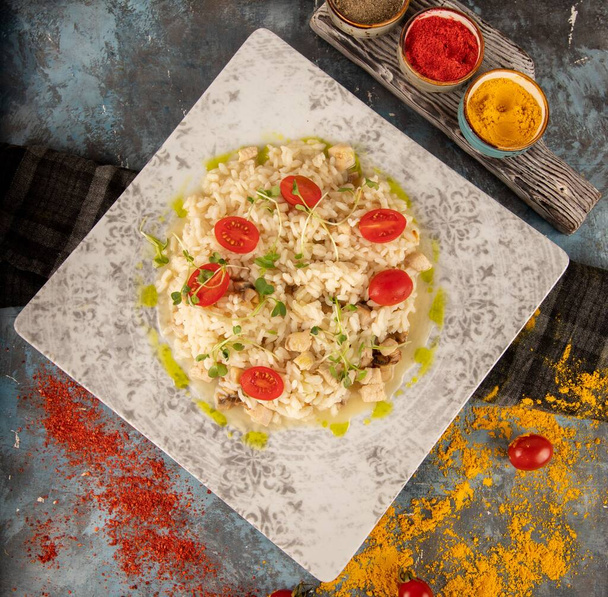 A tasty pasta dish topped with herbs, cheese, and tomatoes on a plate - Photo, Image