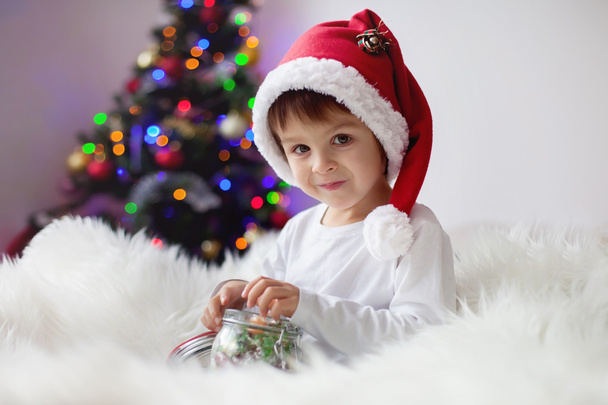 Cute adorable boy enjoying his candy at christmas time - Photo, image