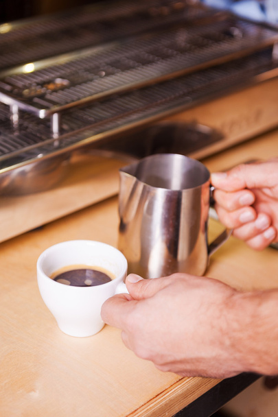 Barista preparing coffee with milk - Foto, afbeelding