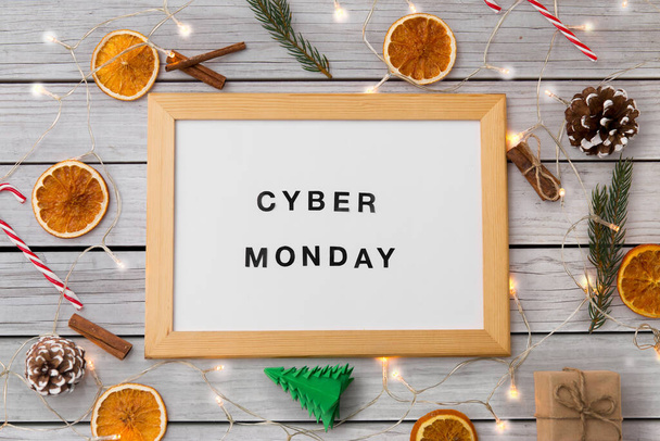 online shopping, season sale and internet marketing concept - white magnetic board with cyber monday words and christmas decorations over grey shabby wooden background - Foto, Imagem
