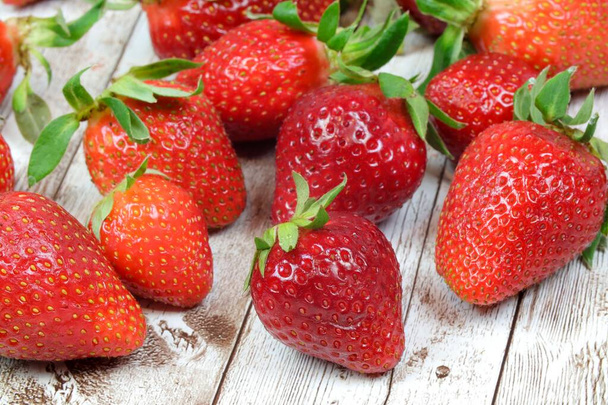 A closeup shot of strawberries on a wooden background - Valokuva, kuva