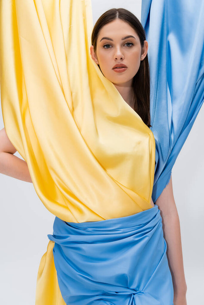 portrait of young ukrainian woman in blue and yellow dress posing isolated on grey - Foto, afbeelding