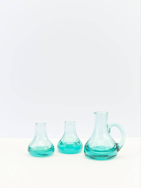 empty glass bottles on a white table with white wall background - Photo, image