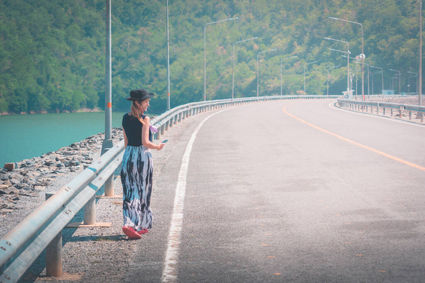Женщина, идущая по обочине плотины в Канчанабури, Таиланд. - Фото, изображение