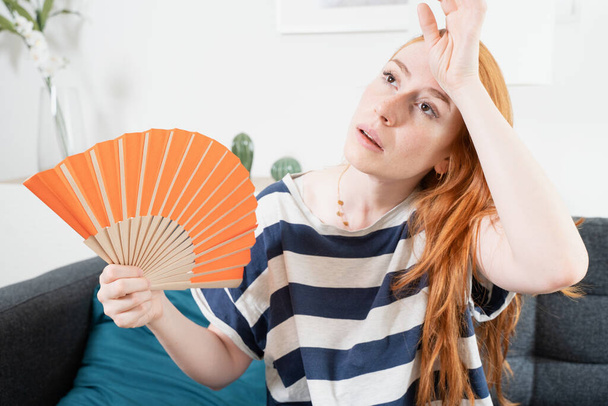 Νεαρή γυναίκα που υποφέρει το καλοκαίρι κύμα καύσωνα στο σπίτι - Φωτογραφία, εικόνα