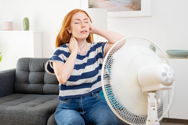 Young woman suffering summer heat wave at home - Fotoğraf, Görsel