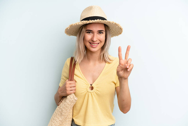 blonde woman smiling and looking friendly, showing number two. summer concept - Foto, Bild