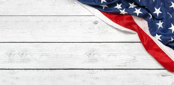 Flat lay USA flag on white wooden board, vintage background with copy space top view. Banner, minimalism. American - 写真・画像