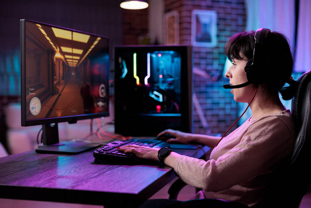 Female player having fun with action video games competition, playing online game championship. Caucasian woman enjoying rpg play tournament on live stream, gaming on computer. - Foto, immagini