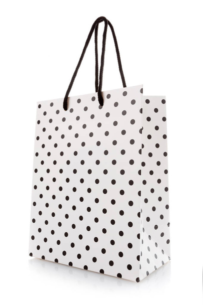 Shopping bag. White package for shopping or gifts with black dots and handles. Concept of gifts for birthday, women's day, mother's day. Isolated on white. - Foto, afbeelding