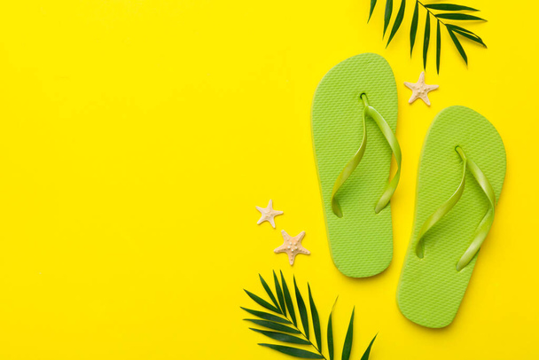 Flat lay composition with flip flops and seashell on colored background. Space for text top view. - Foto, Imagen