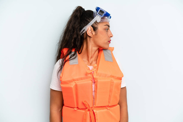 hispanic woman on profile view thinking, imagining or daydreaming. life jacket and summer concept - Fotó, kép