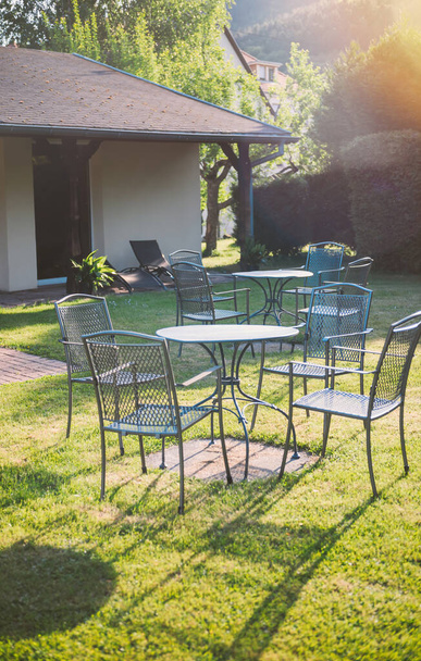 Garden party summer day atmosphere with empty table and chairs, - preparing for guests, summer spring outdoor chillout beautiful sunlight yellow flare - Foto, Imagen