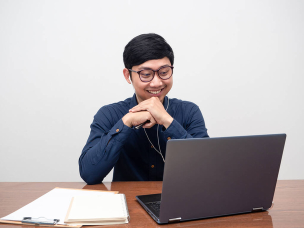 Mladý muž nosí sluchátka pracující s notebookem na stole, muž pracující na pracovišti - Fotografie, Obrázek