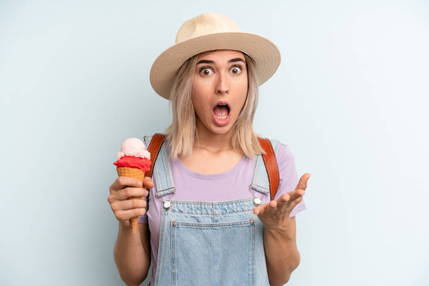 blonde woman amazed, shocked and astonished with an unbelievable surprise. ice cream and summer concept - Foto, imagen
