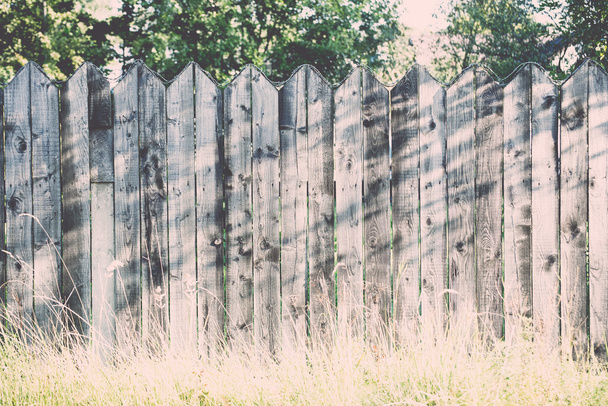 старый деревянный забор с колючей проволокой сверху. Винтаж
. - Фото, изображение