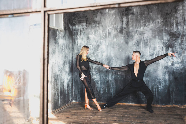 Δυο επαγγελματίες χορευτές χορεύουν στο στούντιο της σοφίτας. Όμορφη καλλιτεχνική παράσταση. Αθλητική ζωή έννοια. Πάθος και συναισθηματικός χορός. - Φωτογραφία, εικόνα