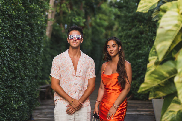 Foto de moda de una atractiva pareja joven en ropa de verano posando al aire libre - Foto, Imagen