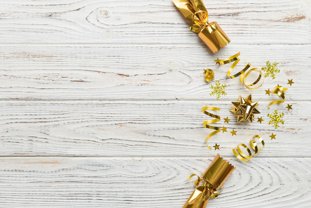 Weihnachts-Cracker mit glänzendem Konfetti auf farbigem Hintergrund, Draufsicht, Kopierraum. - Foto, Bild