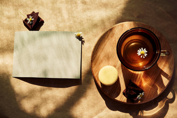 Esztétikai nyár tea idő, gyógynövény tea és macaron desszert kívül a teraszon trendi kemény árnyékok. Levélpapír minta kívánság, üdvözlés, meghívók vagy recept készítéséhez - Fotó, kép