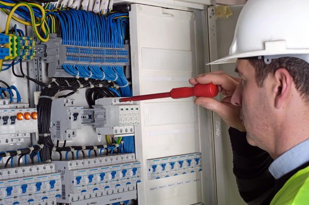 Eletricista durante a medição
 - Foto, Imagem