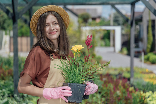 Gardener with plants in garden center. - Photo, Image