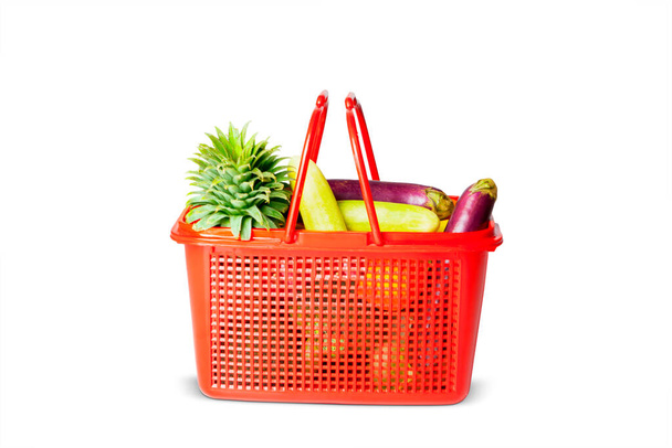 Close up of red plastic basket with fresh vegetables in the studio. Isolated on white background - Foto, Bild
