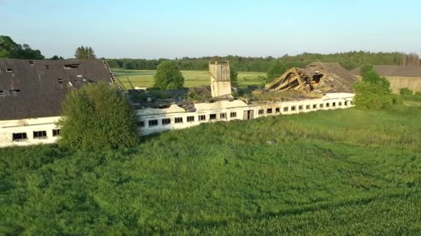 Koeru.Estonia-July 5.2021: Drone shot of a ruined soviet cattle barn. Природа медленно захватывает старое разрушающееся здание. Камера движется боком и поворачивает направо. - Кадры, видео