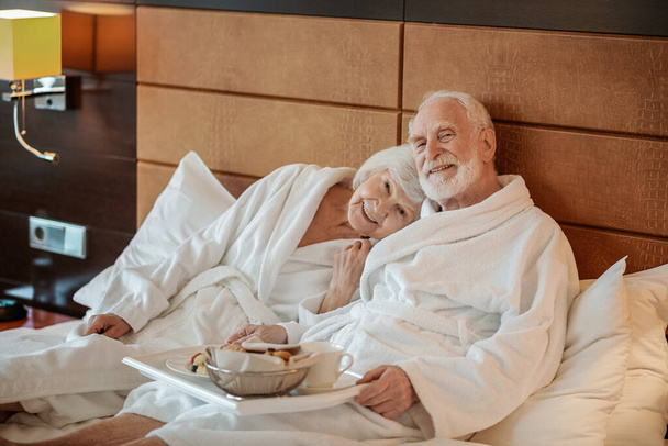 Good time. Senior couple spending weekend in a hotel and looking contented - Foto, Bild