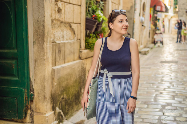 Woman tourist enjoying Colorful street in Old town of Kotor on a sunny day, Montenegro. Travel to Montenegro concept. - Foto, imagen