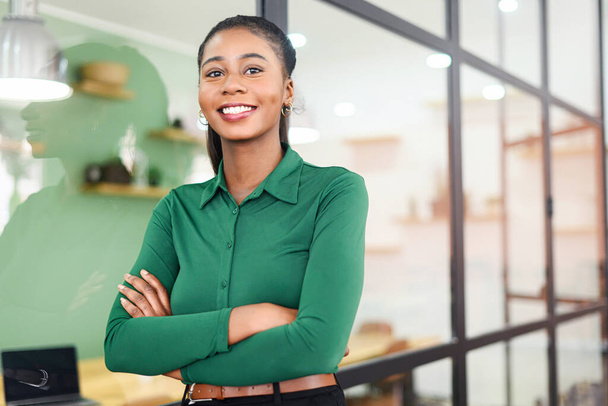 Portrait of confident African-American businesswoman standing with arms crossed, multiracial female office employee in smart casual wear looking at the camera and smiles - Foto, Imagen